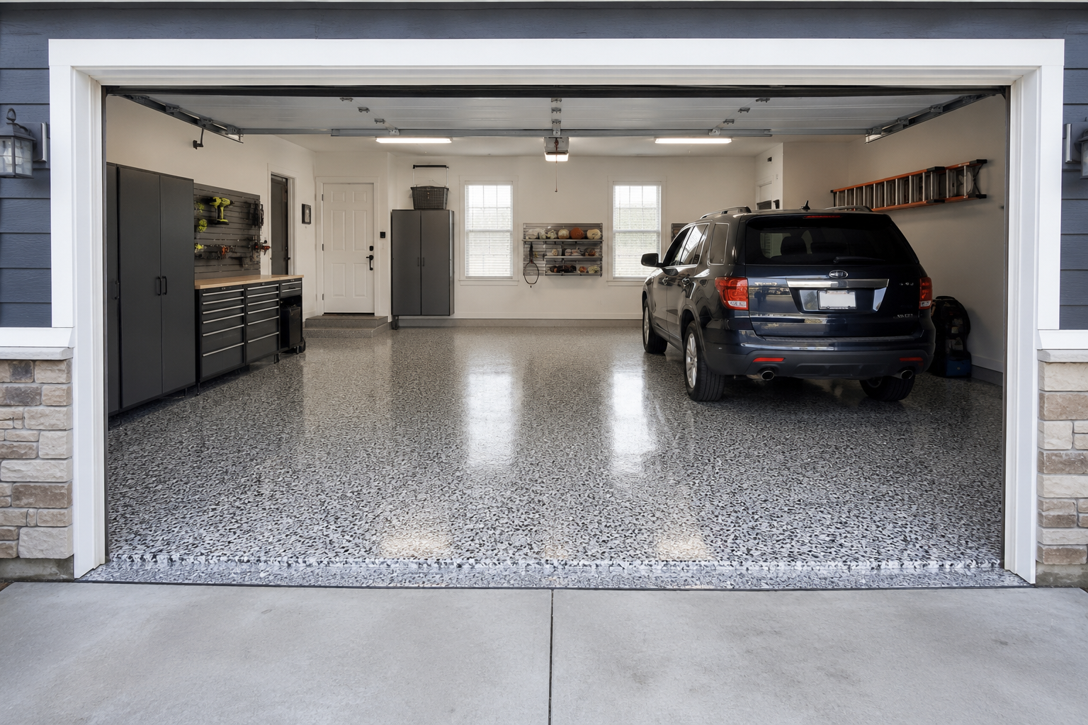 Two-car garage with a glossy gray decorative-flake epoxy floor, organized cabinets, and an SUV parked inside, in a Fulshear home